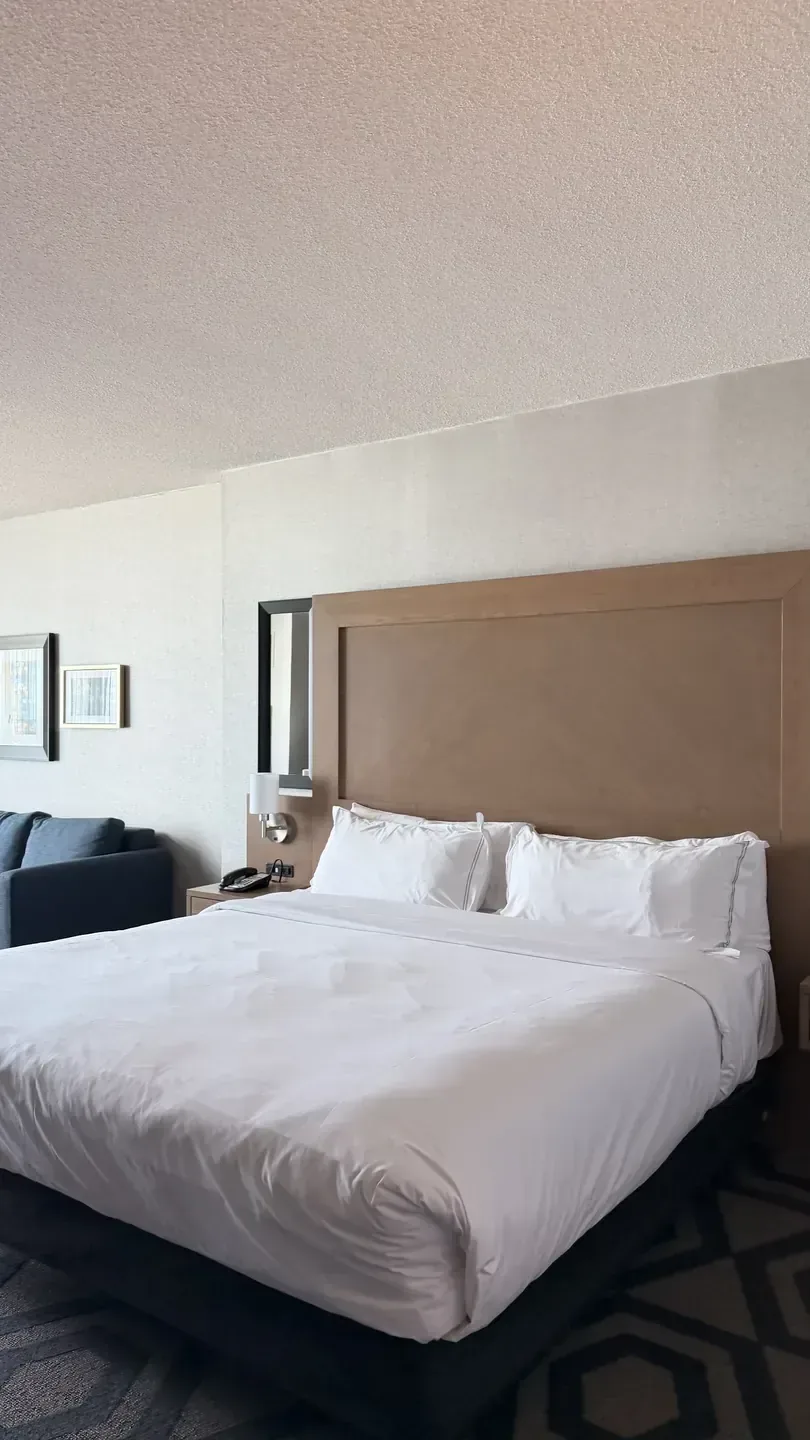 A guest room at Caesars Windsor in Windsor, Ontario, with a made bed and an upholstered headboard